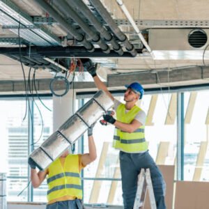 Worker making an HVAC air duct.  Man setting up ventilation system indoors