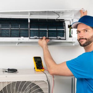 Installation service fix  repair maintenance of an air conditioner indoor unit, by cryogenist technican worker checking the air filter in blue shirt and baseball cap